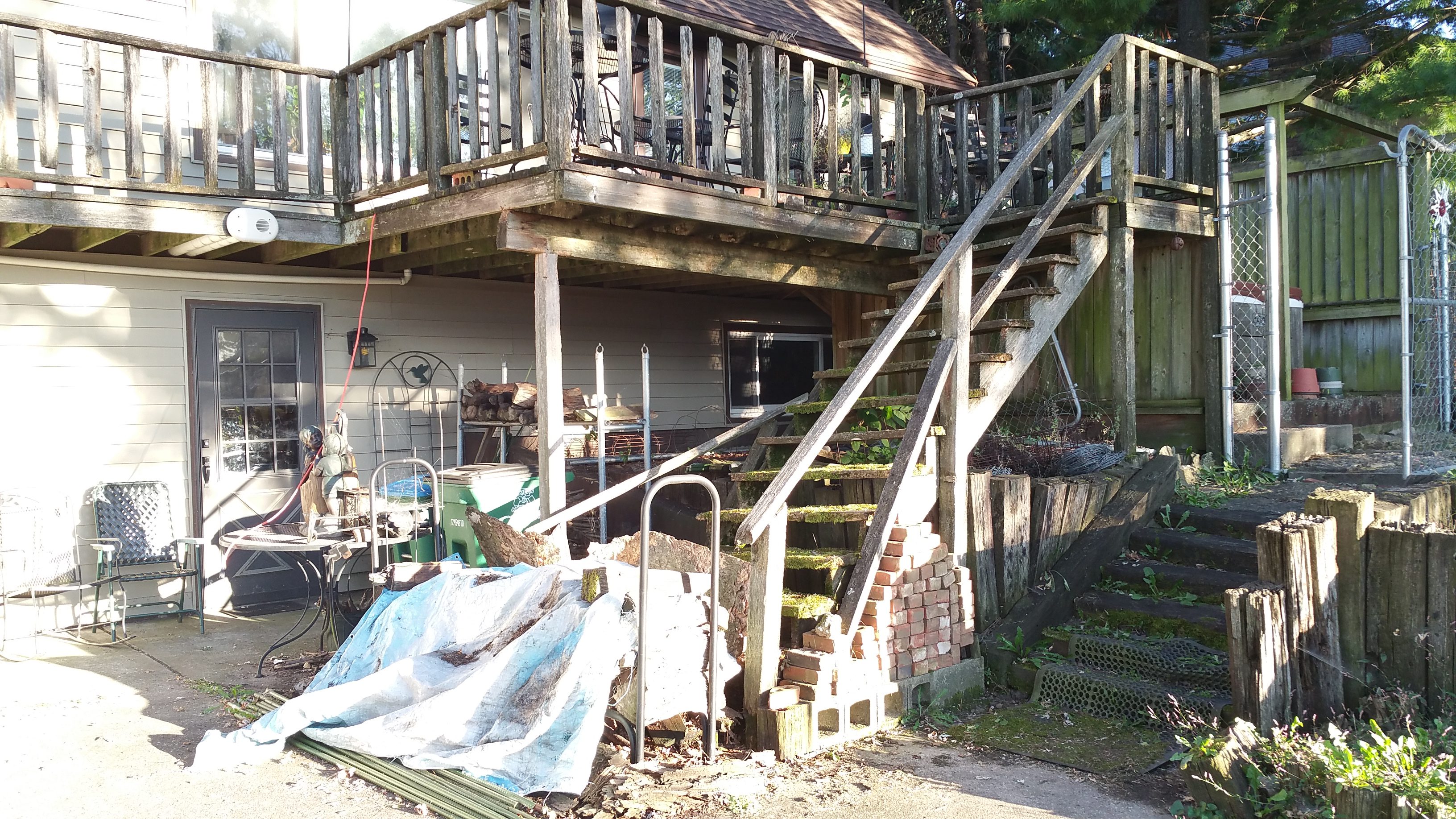 Exterior view of a weathered wooden staircase leading to a porch.