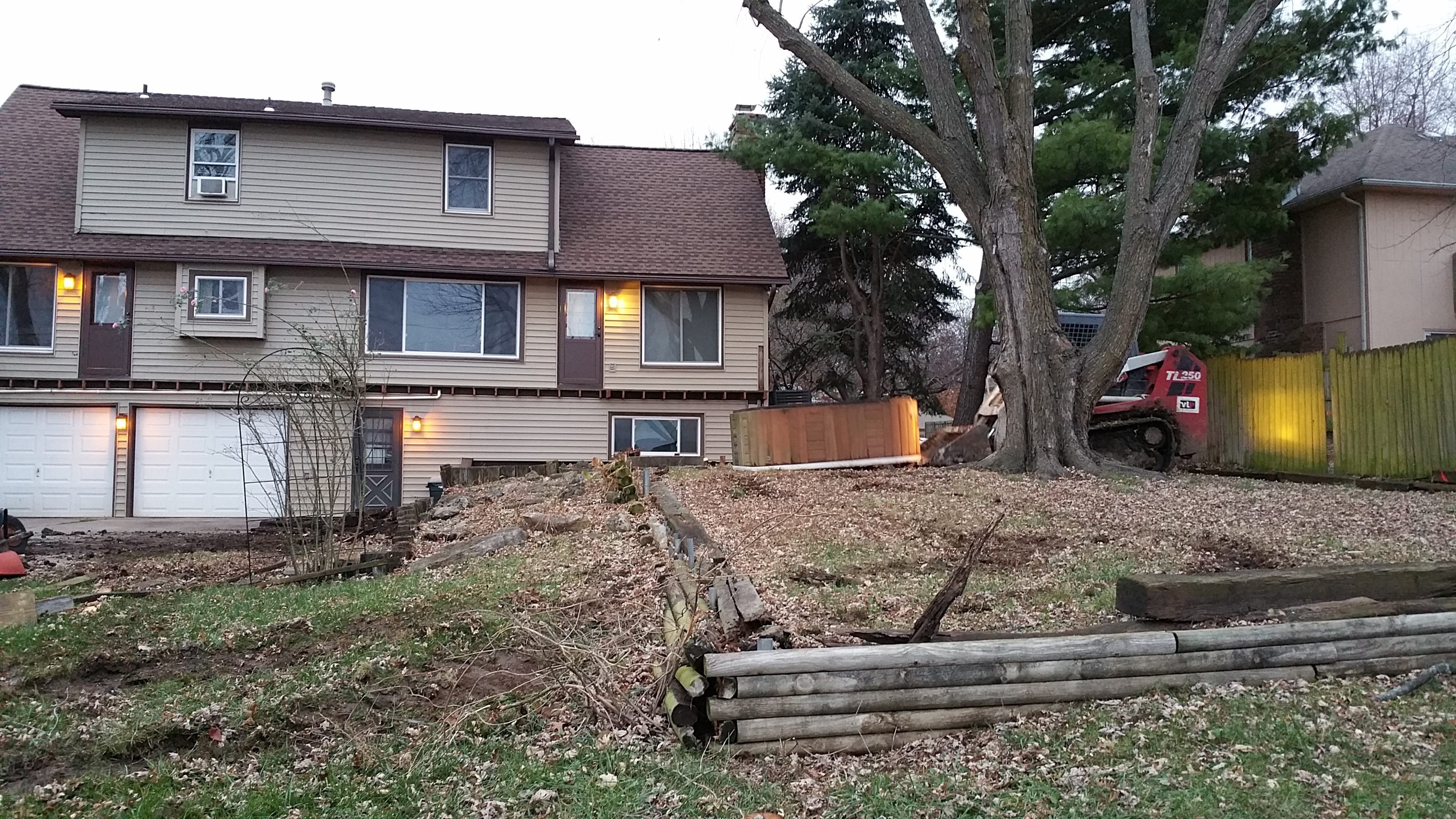 A house with a split-level design and a large tree in the yard.