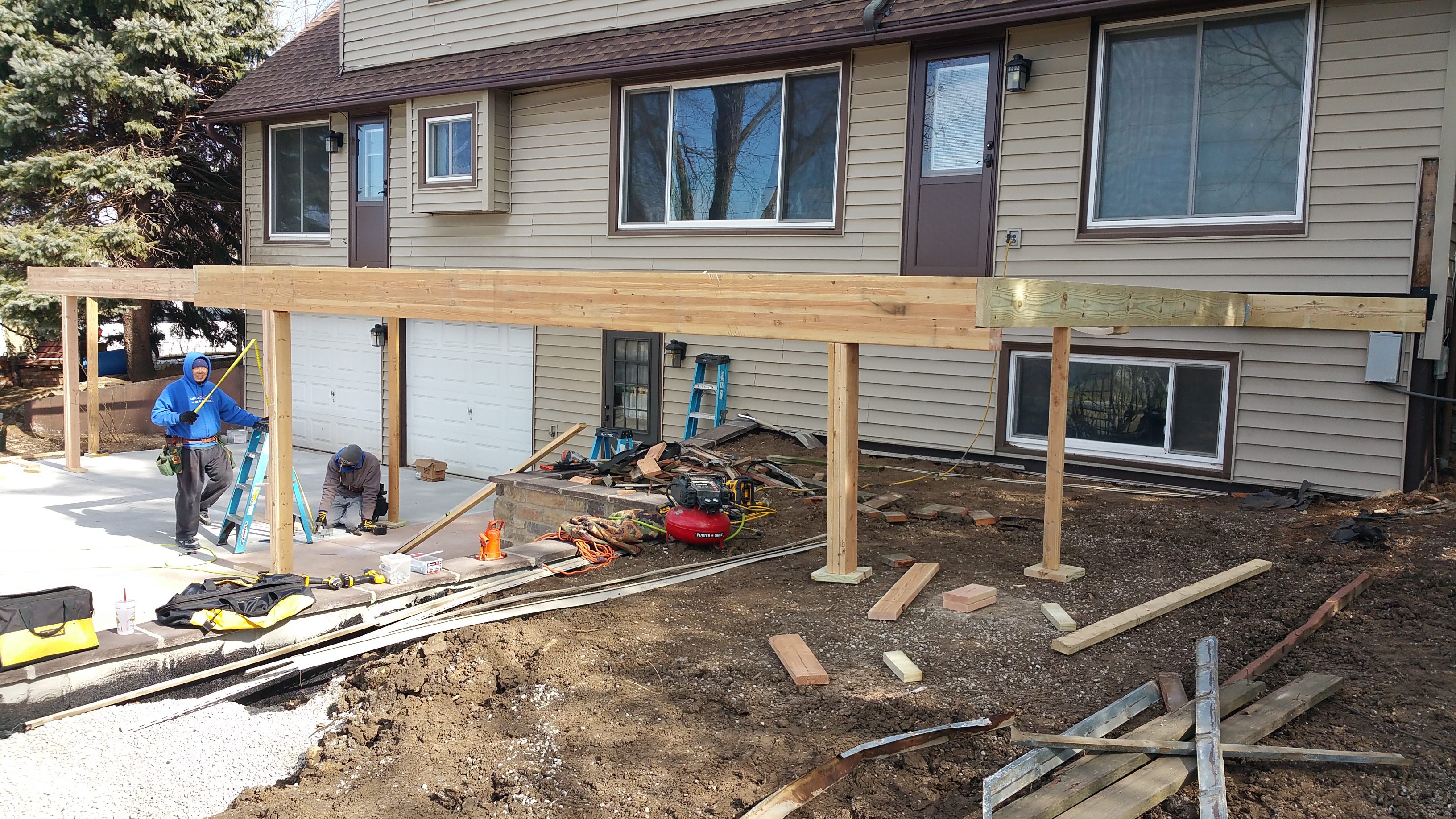 Wooden deck frame construction in progress attached to a house.