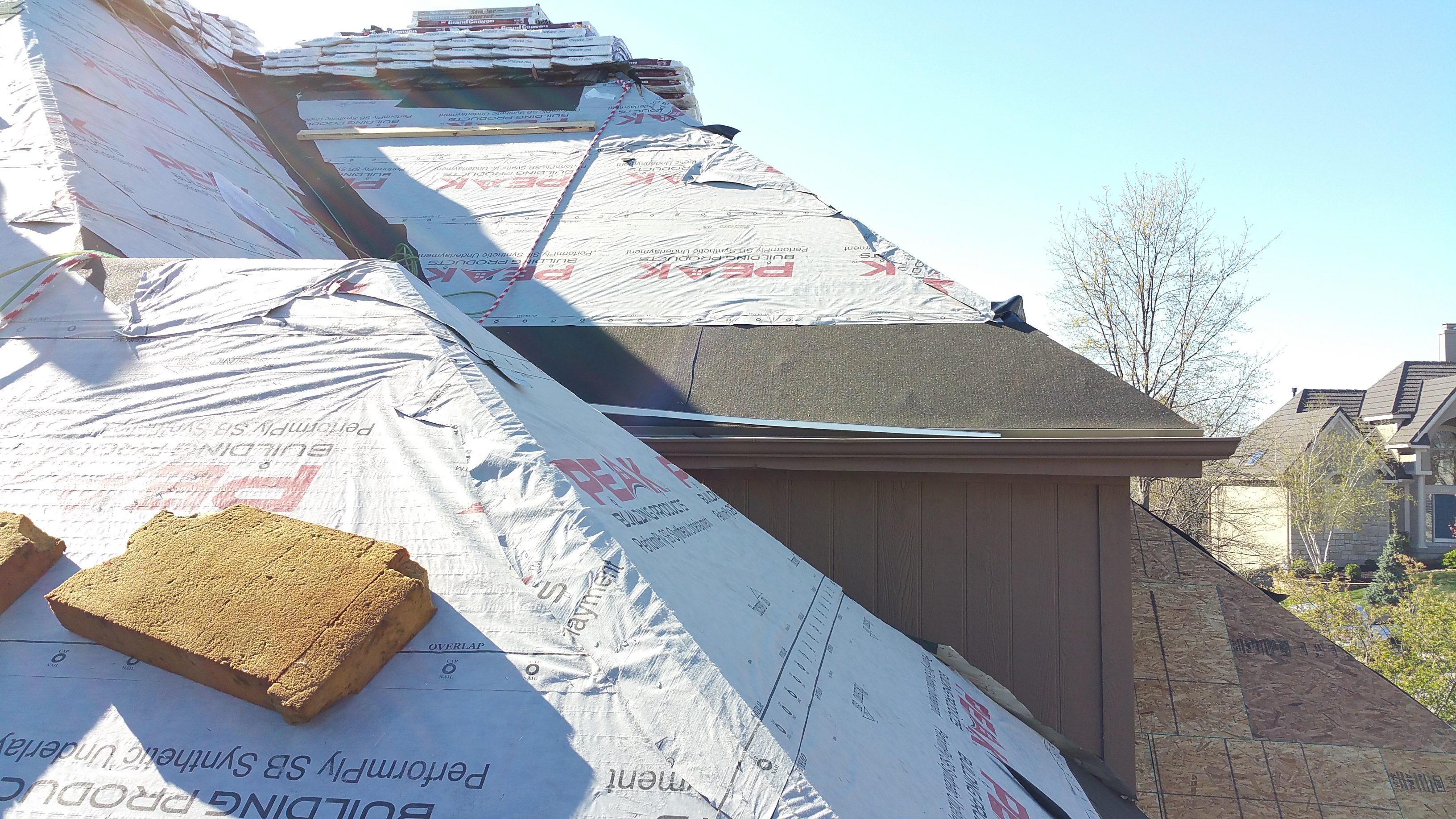 Roof under construction with insulation and wooden framework visible.