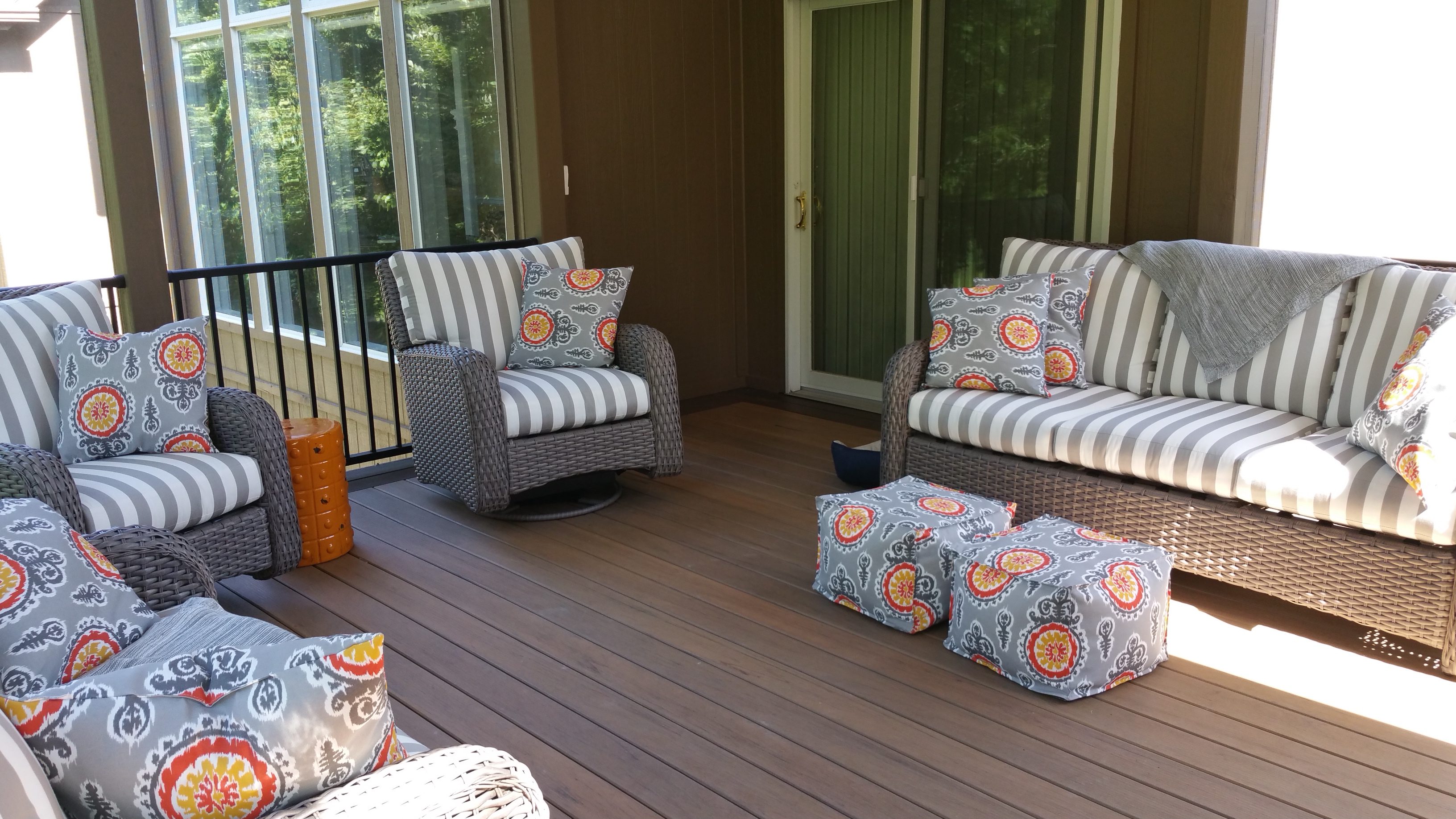 Cozy outdoor seating area with striped chairs and vibrant cushions on a wooden deck.