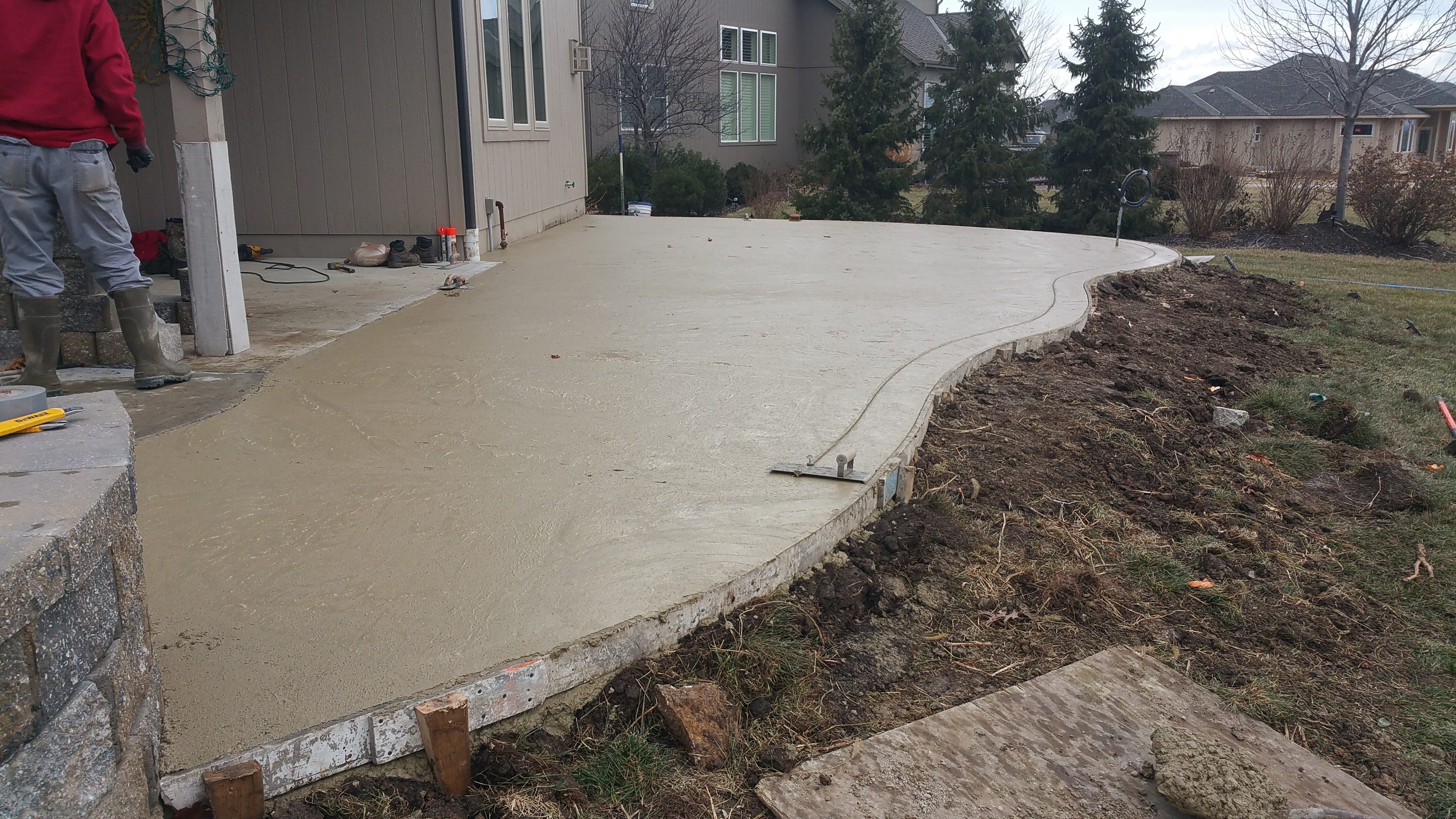 Freshly poured concrete patio beside a house.