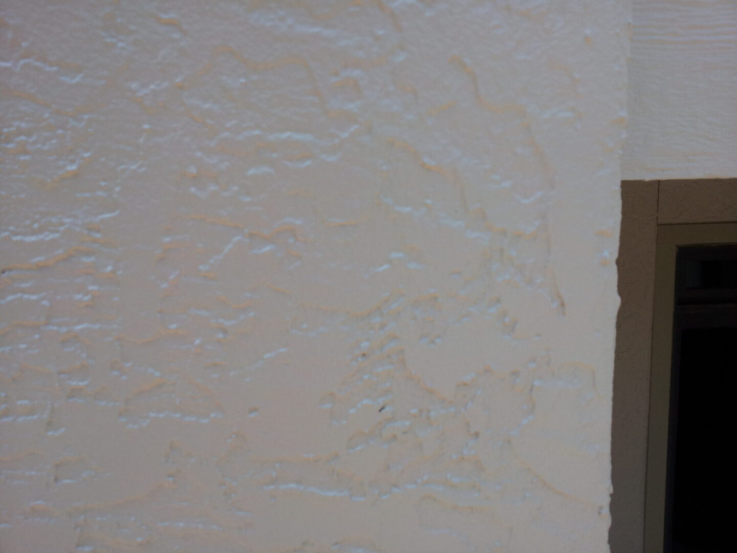 Close-up of textured white wall with subtle patterns.