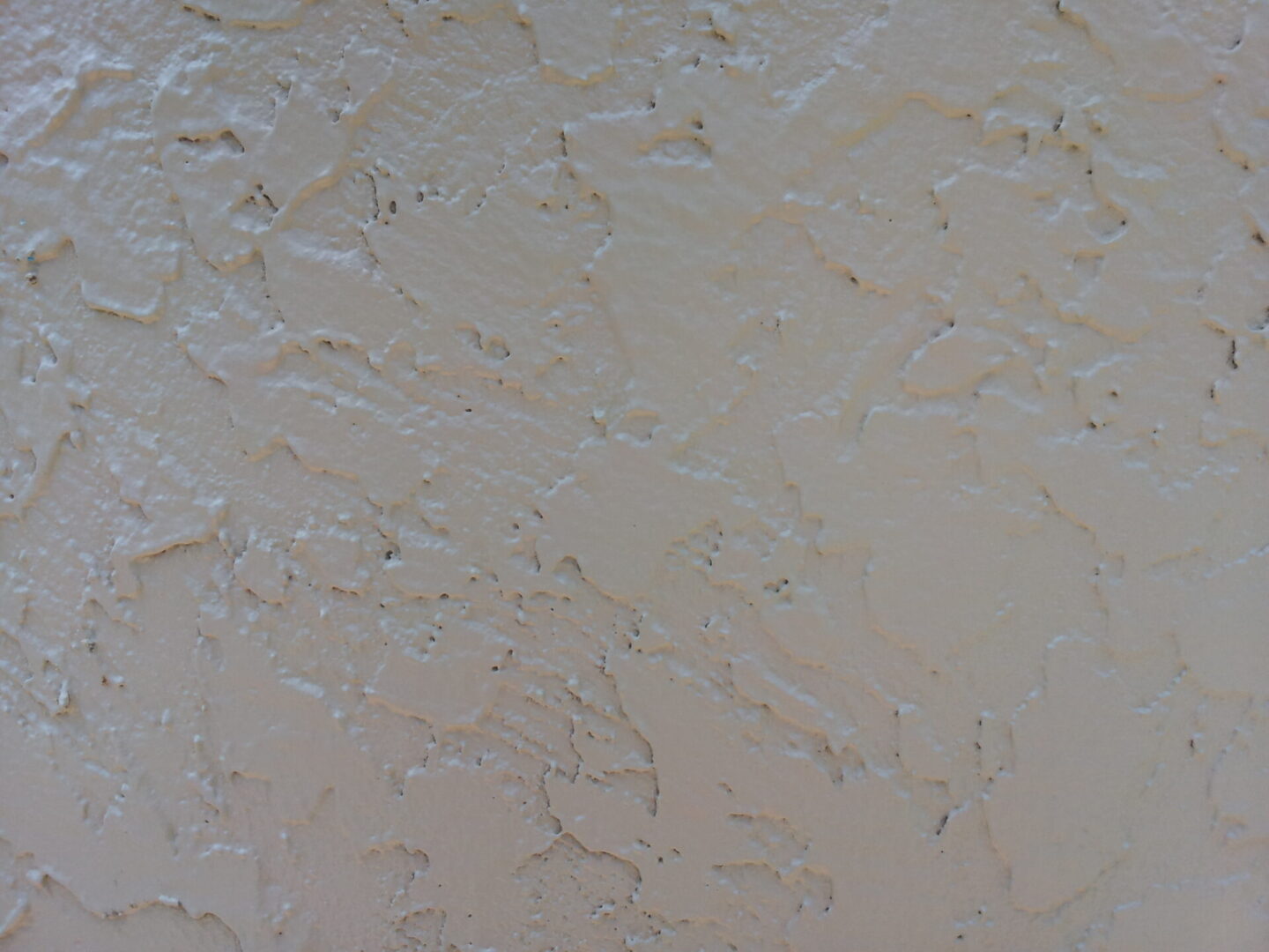Close-up of a textured beige wall with subtle patterns.