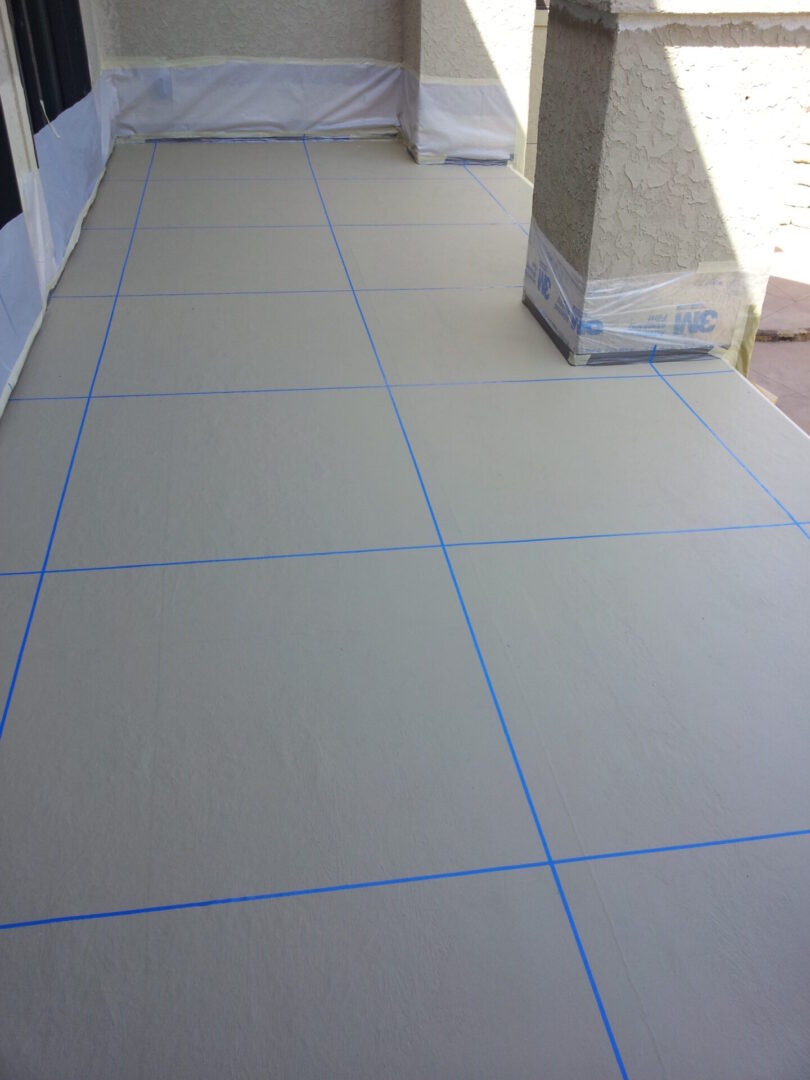 Floor tiles arranged with blue grid lines on a smooth surface.