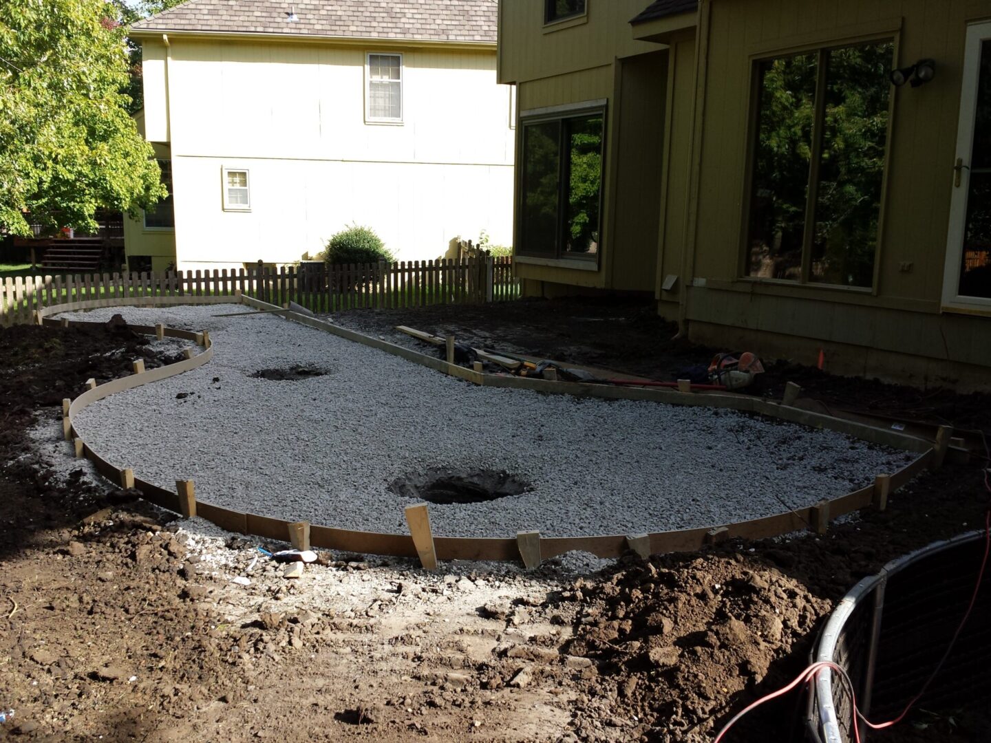 Backyard landscaping with gravel and stone arrangement.