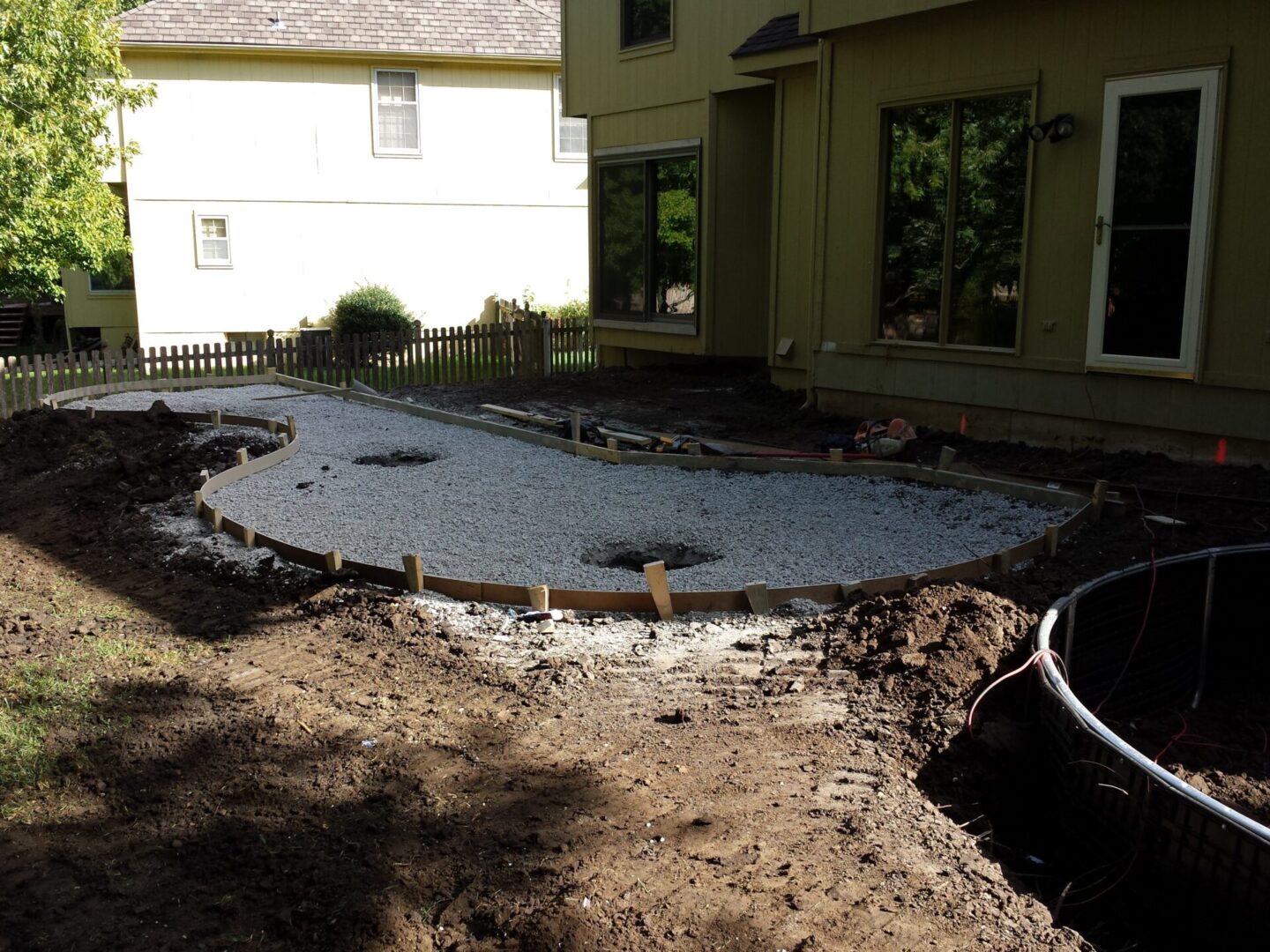 Construction site preparing foundation with gravel and soil around.
