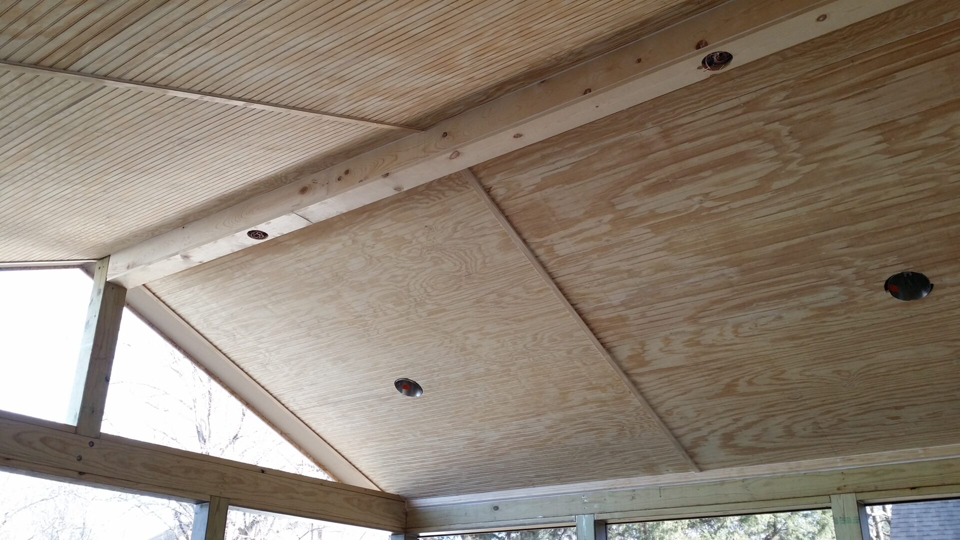 Wooden ceiling with exposed beams and some small dark spots.
