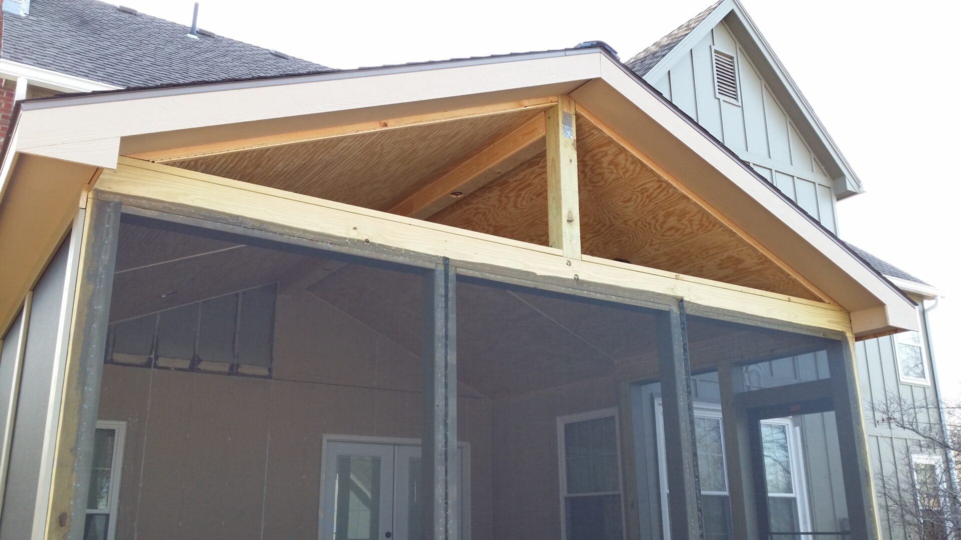 Partially constructed porch roof with exposed wood framing.
