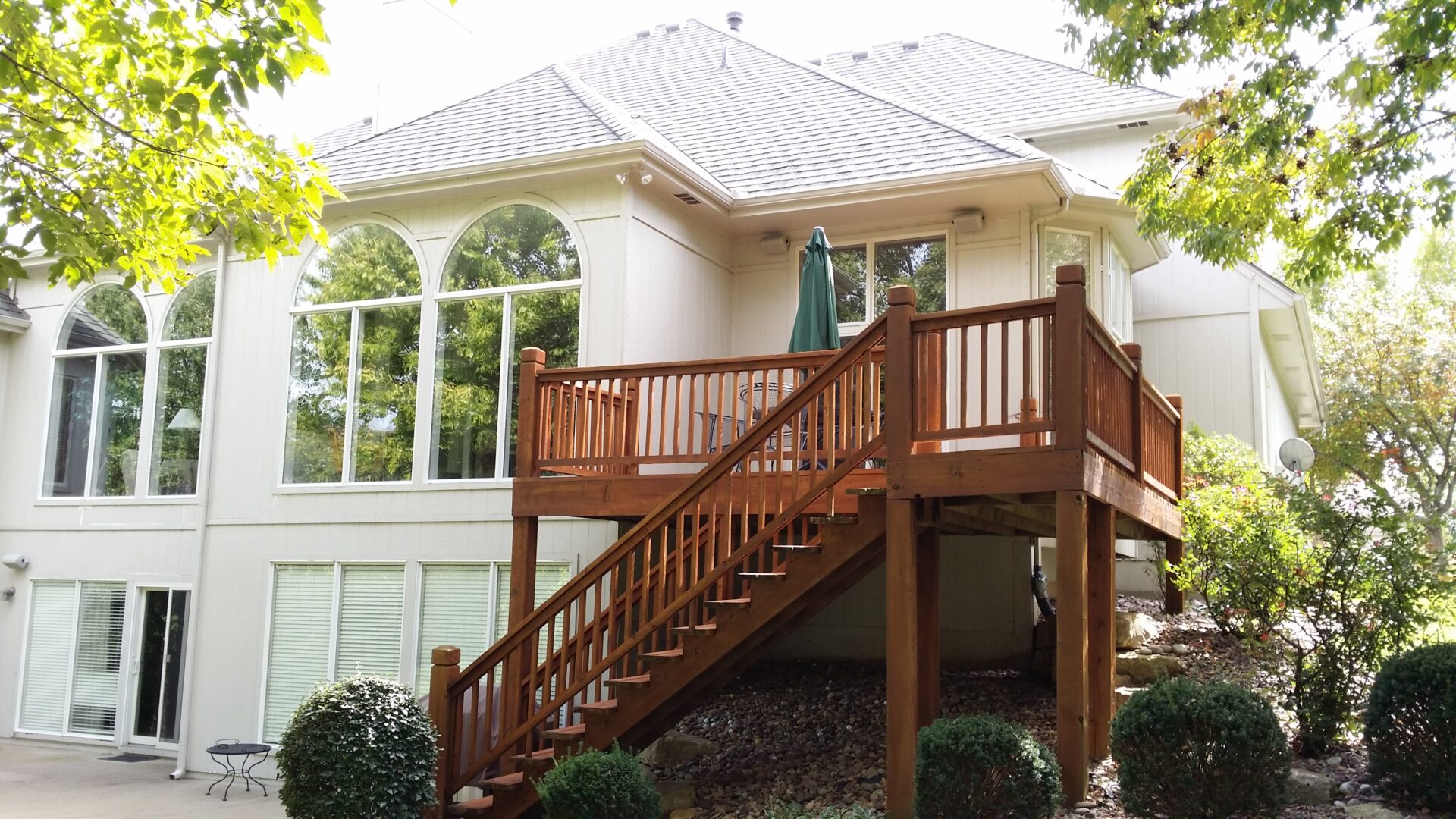 A wooden staircase leading to a porch on a white house.