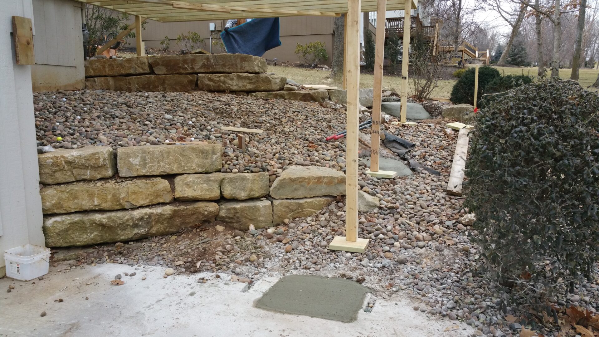 A garden area with stone edging and a wooden post.