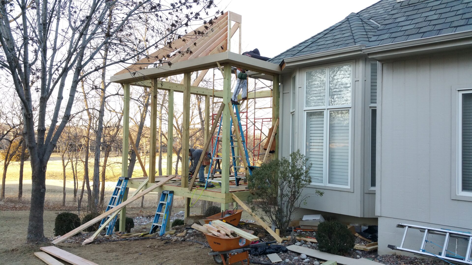 Construction of a wooden deck attached to a house’s exterior.
