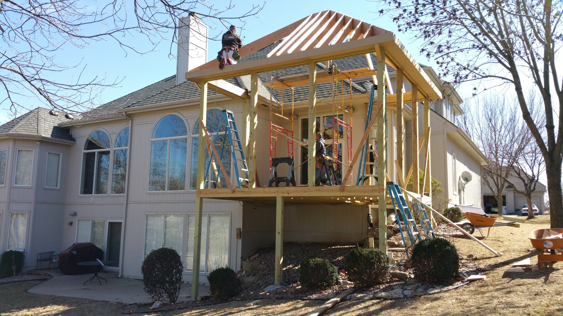 Construction workers building a wooden extension on a house.