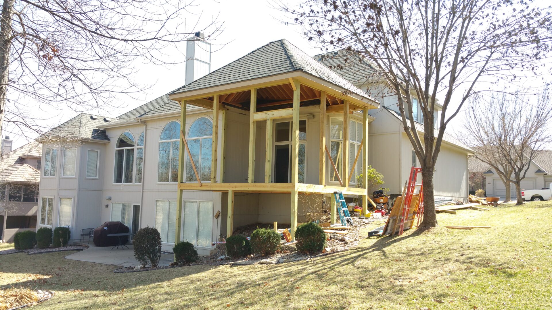 House with a screened porch under construction in a yard.