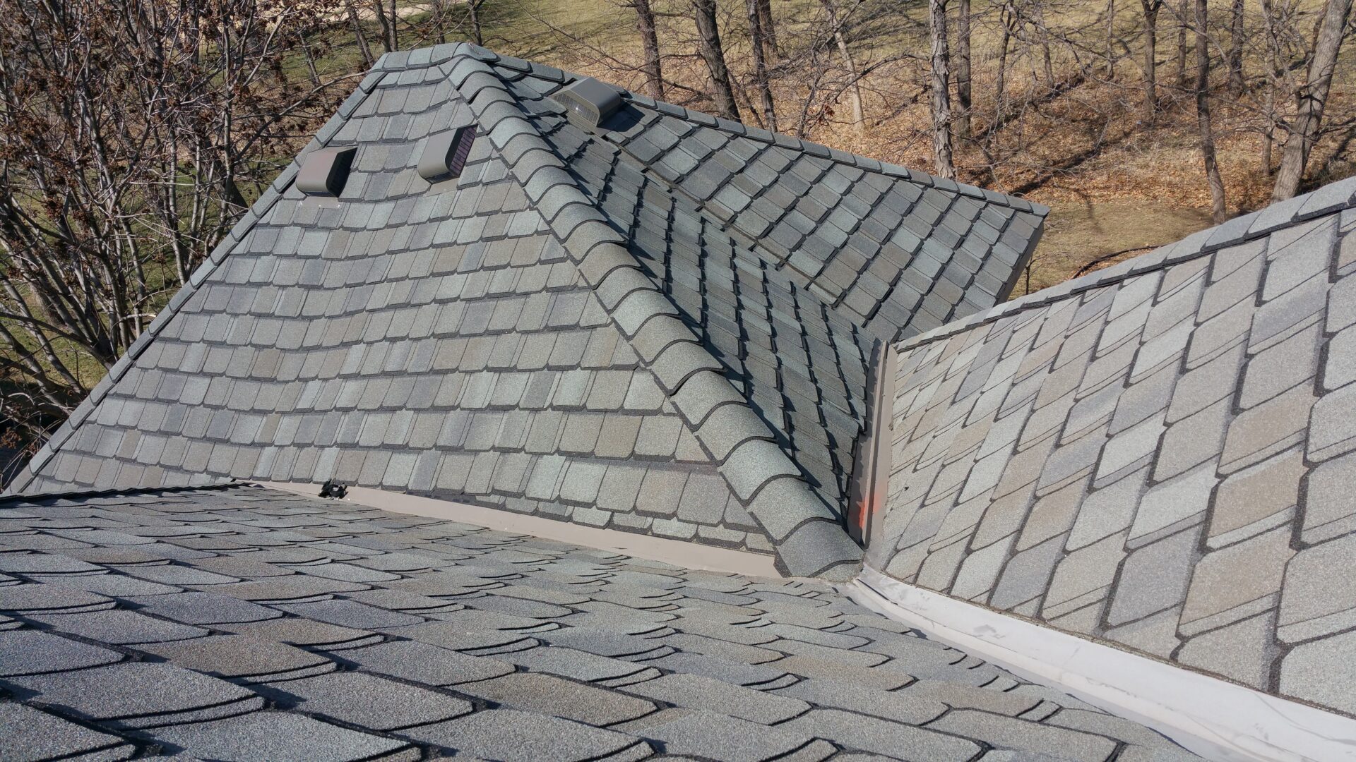 Close-up of a shingled roof with a valley section.