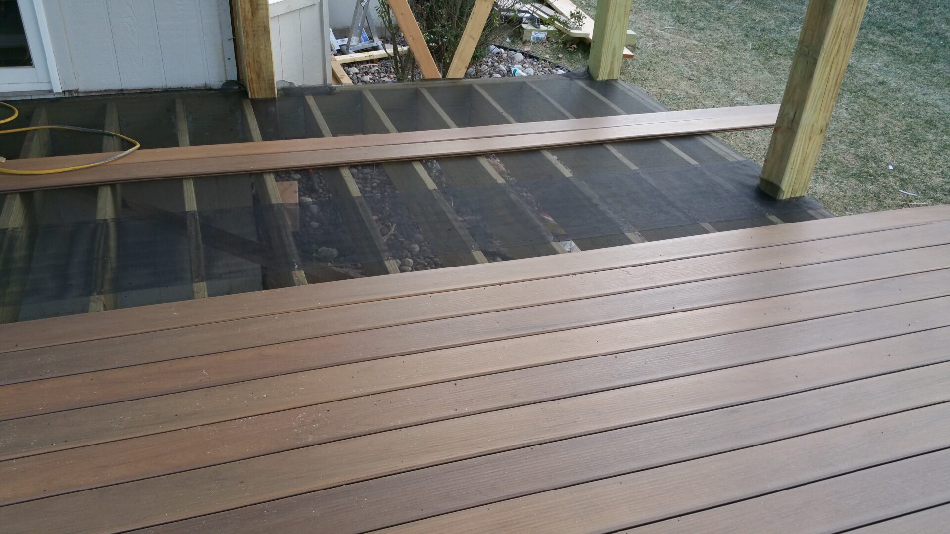 Wooden deck under construction with planks being installed.