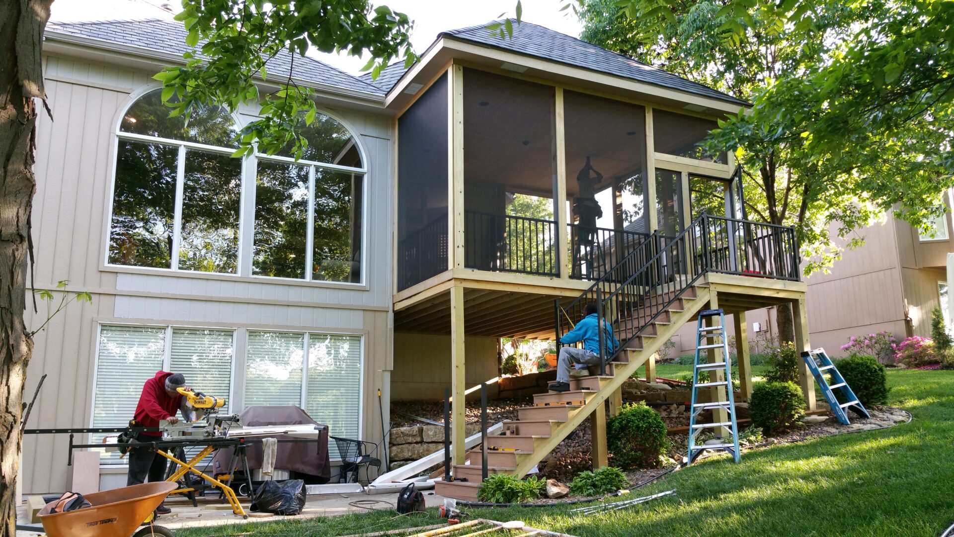 A modern house with a screened porch and outdoor stairs.