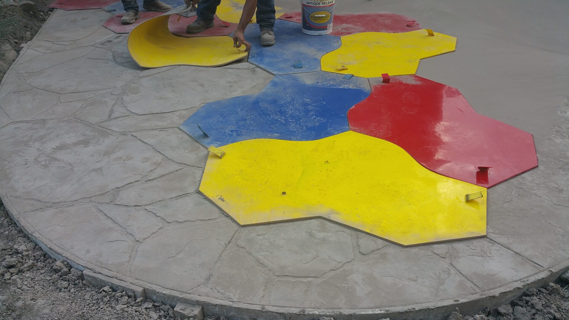Colorful hexagonal stepping stones on a paved surface.