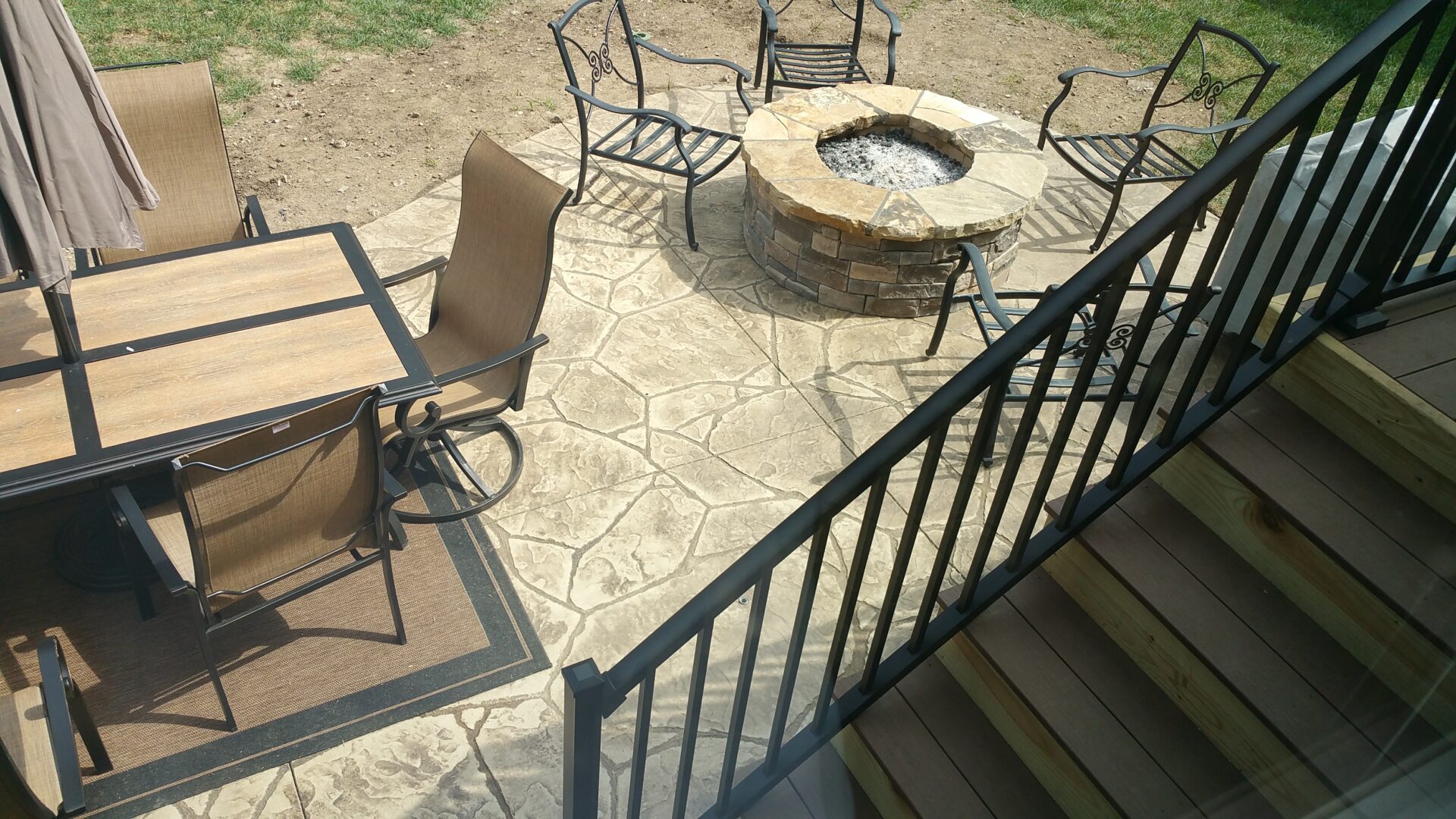 Outdoor patio area with stone fire pit and seating.