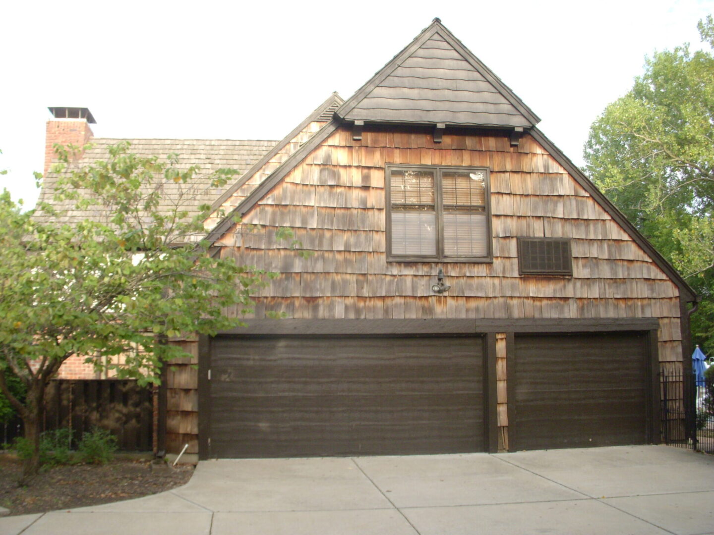 A rustic wooden house with a large three-car garage.