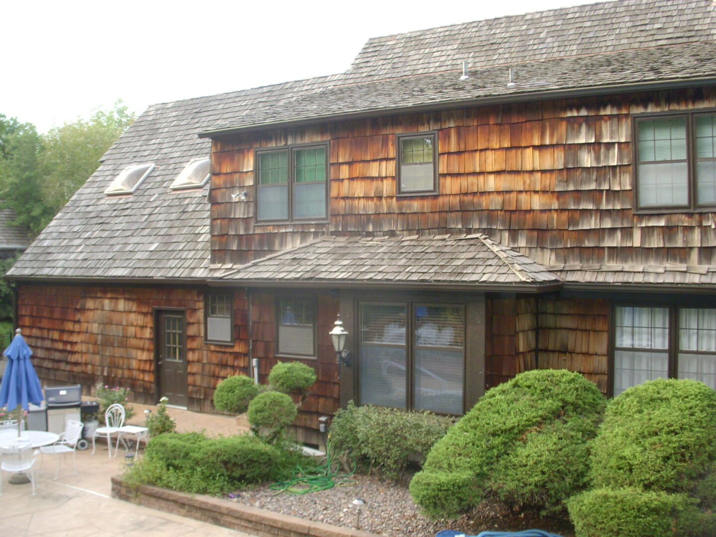 Rustic wooden house with lush greenery in front.