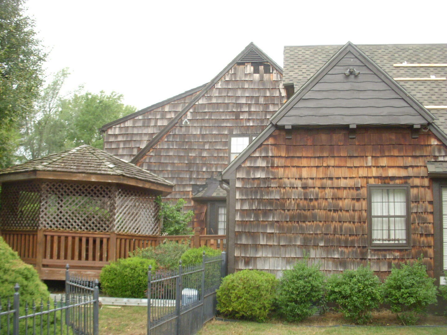 Rustic wooden houses with shingled roofs amidst greenery.
