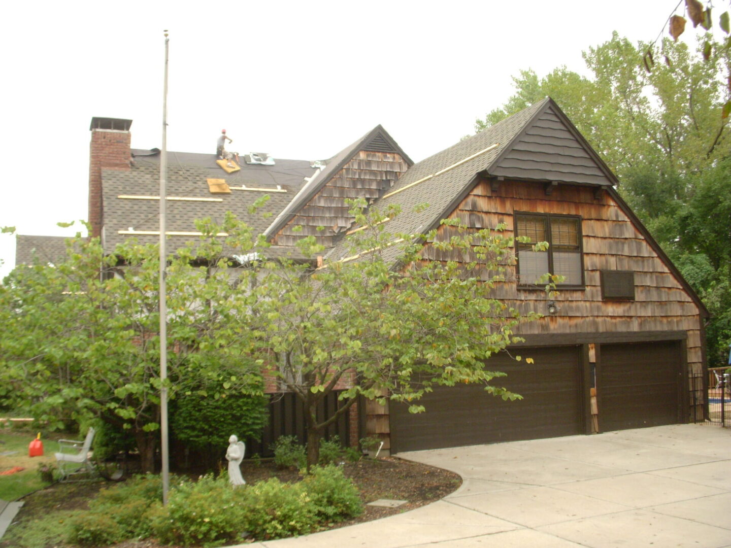 Residential house with brick and wood exterior and a driveway.