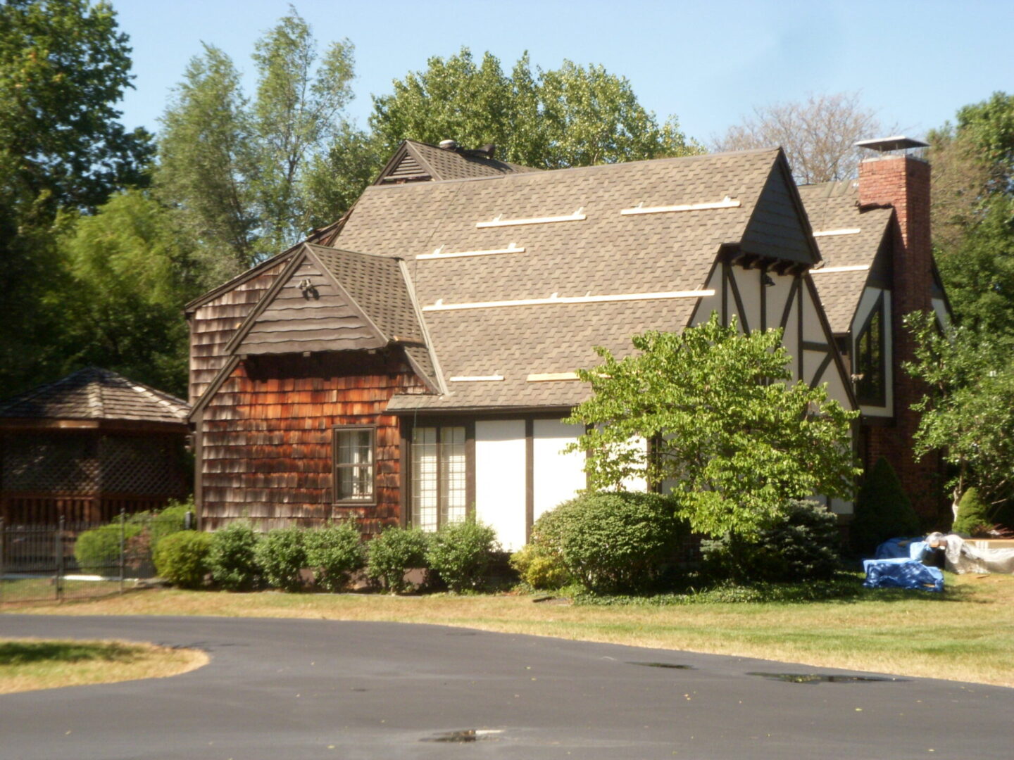 Charming suburban house with a sloped roof and lush greenery.
