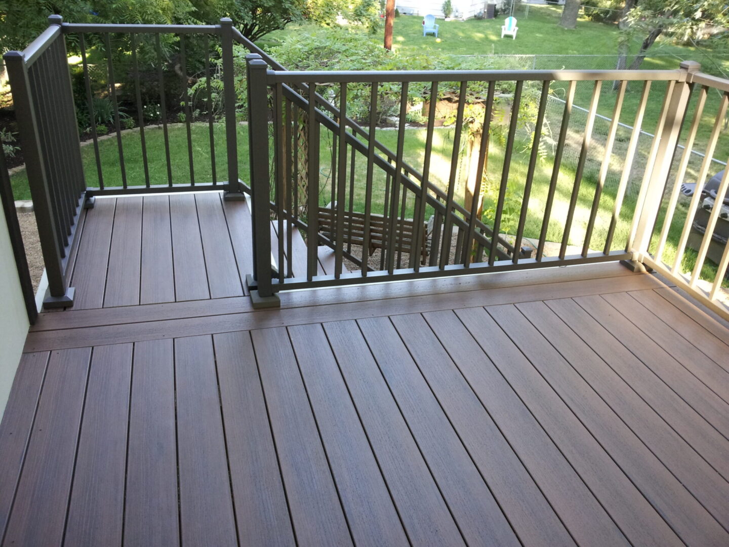 Newly installed composite deck with black metal railing and stairs.