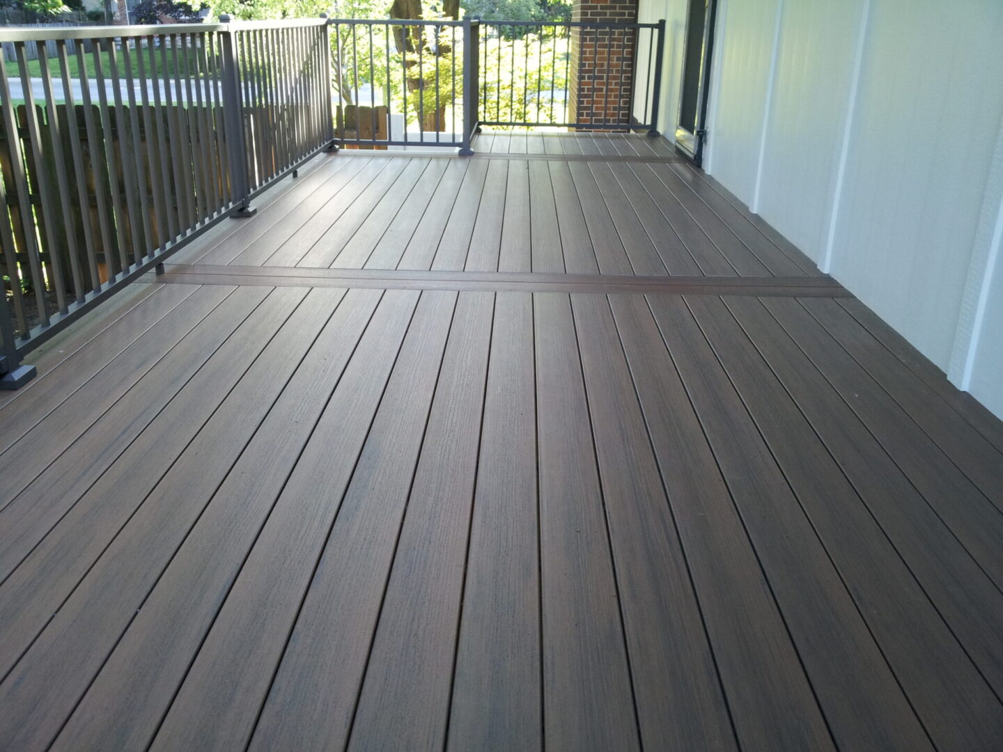 A clean, empty wooden deck with railing and door access.