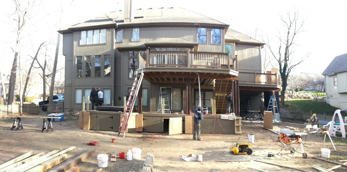A building under construction with workers and equipment outside.