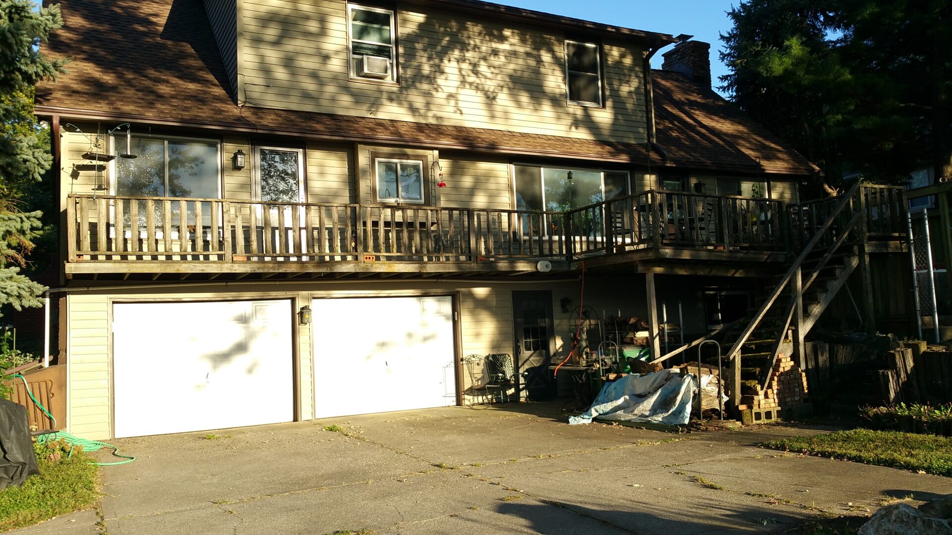 A two-story house with a balcony and garage under sunlight.