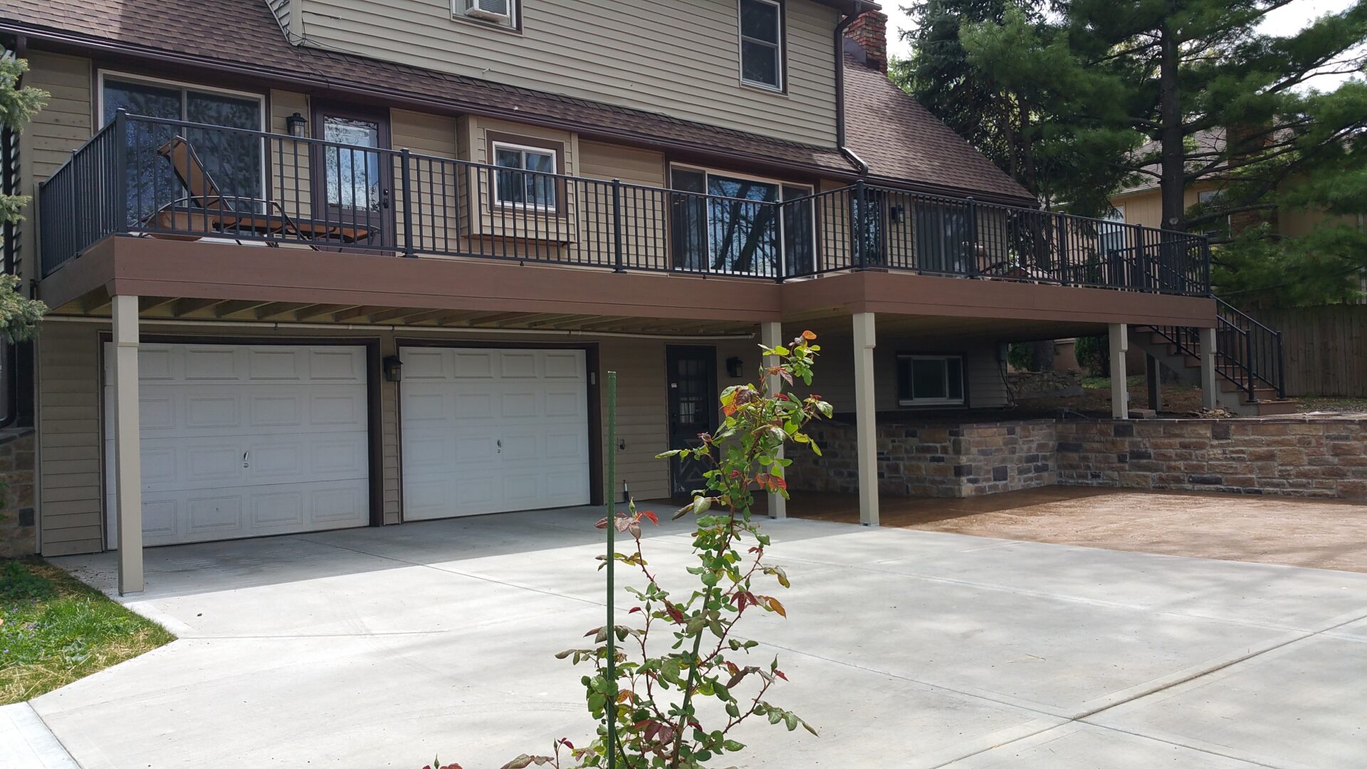A two-story house with a driveway and garage doors.
