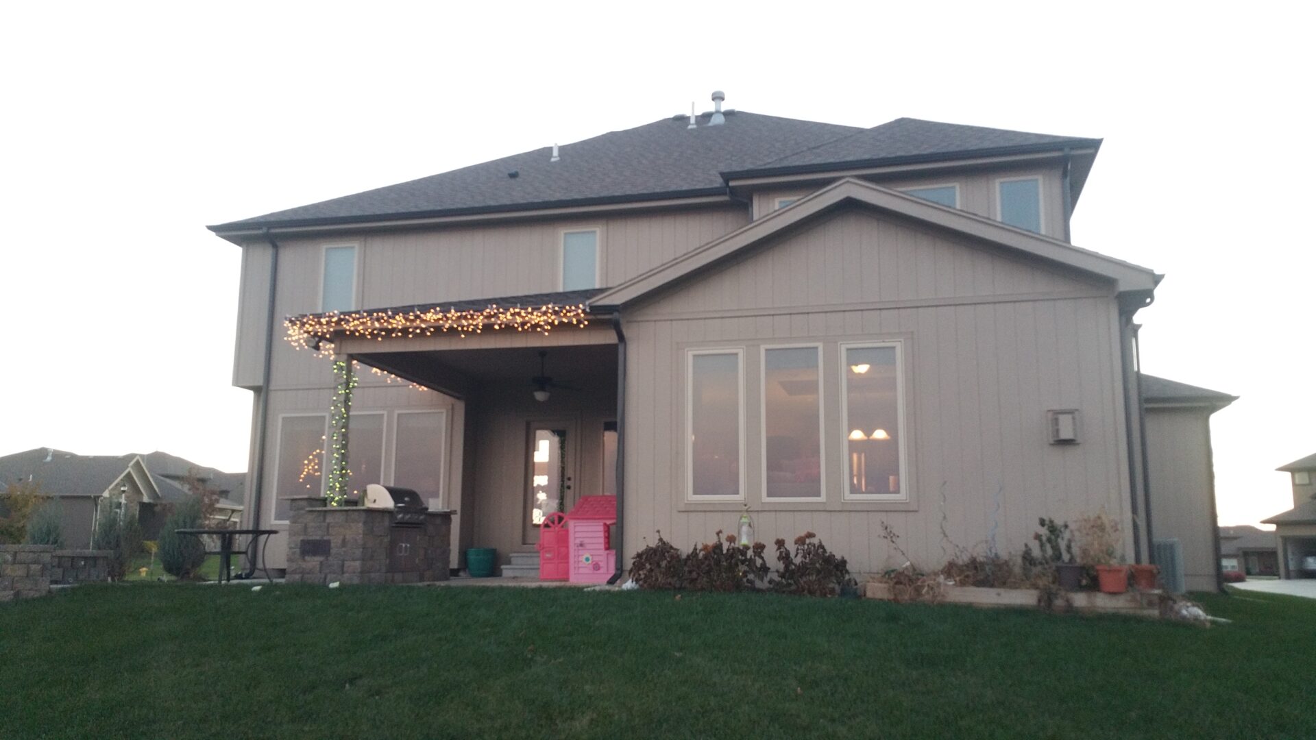 Backyard patio with string lights and a covered seating area.