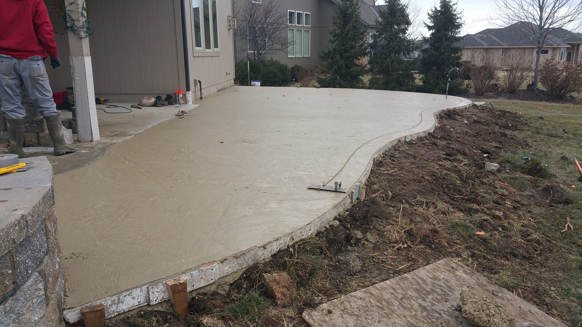 Freshly poured concrete patio next to a house.