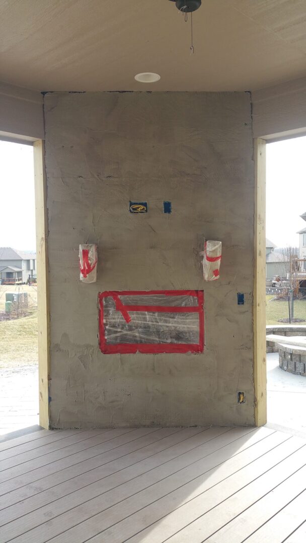 Worn-out signs with red borders on a concrete wall between two openings.