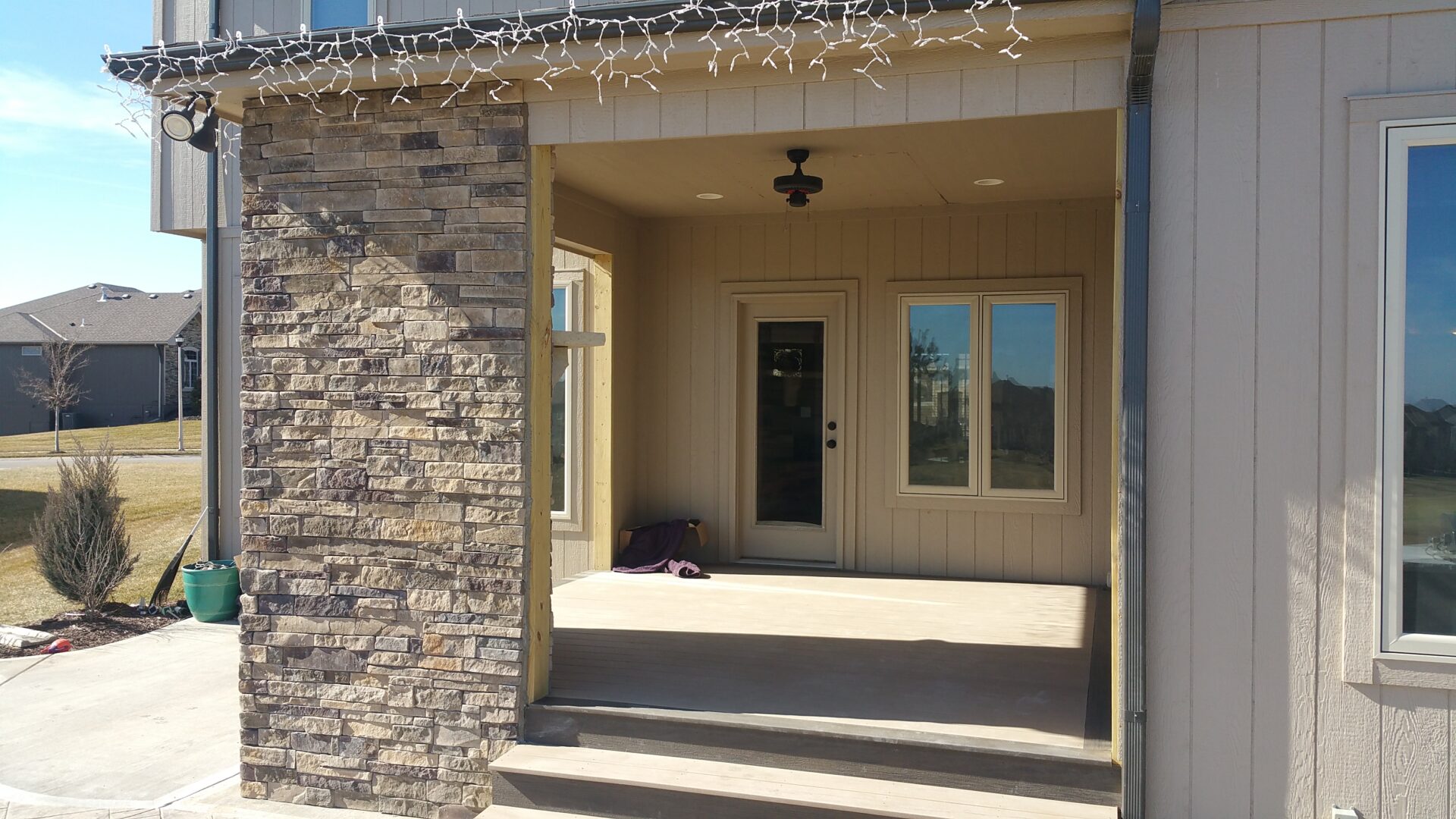 Cozy porch with a bench and hanging light under a covered entrance.