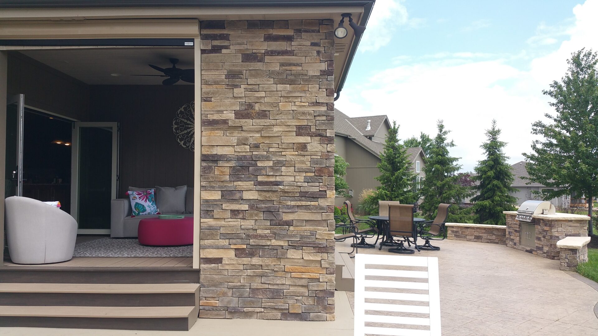 Outdoor patio area with stone pillar and seating.