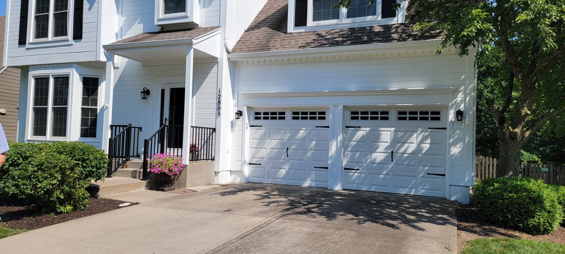 White garage doors with small windows on a suburban house.