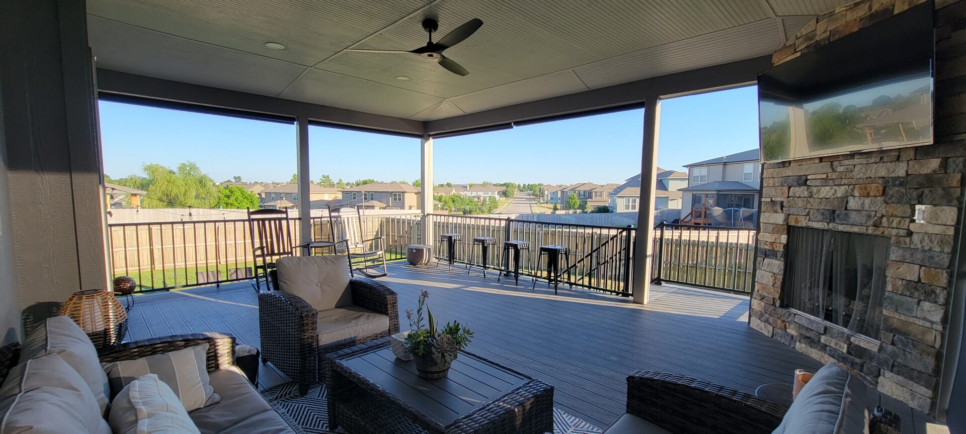 Cozy covered porch with seating overlooking a sunny neighborhood.