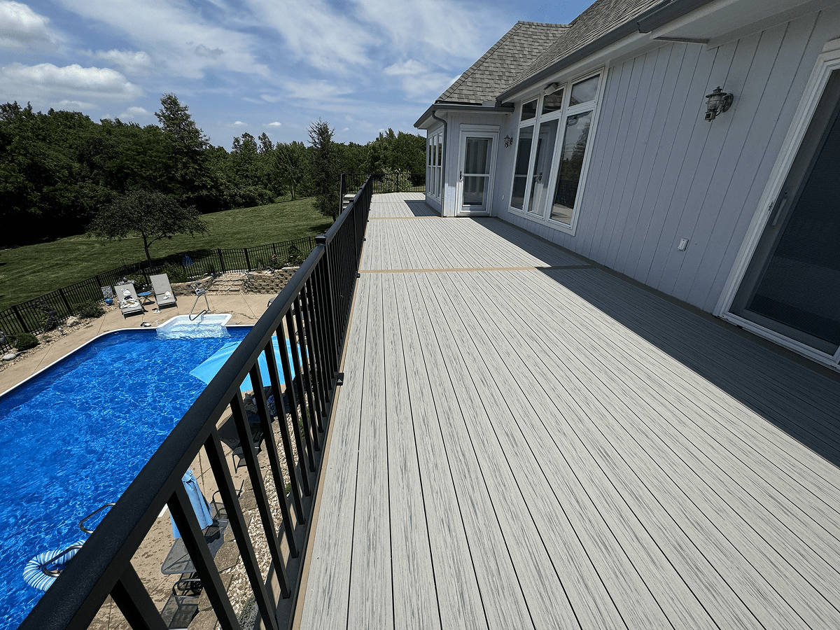 Spacious deck overlooking a backyard pool with outdoor seating.