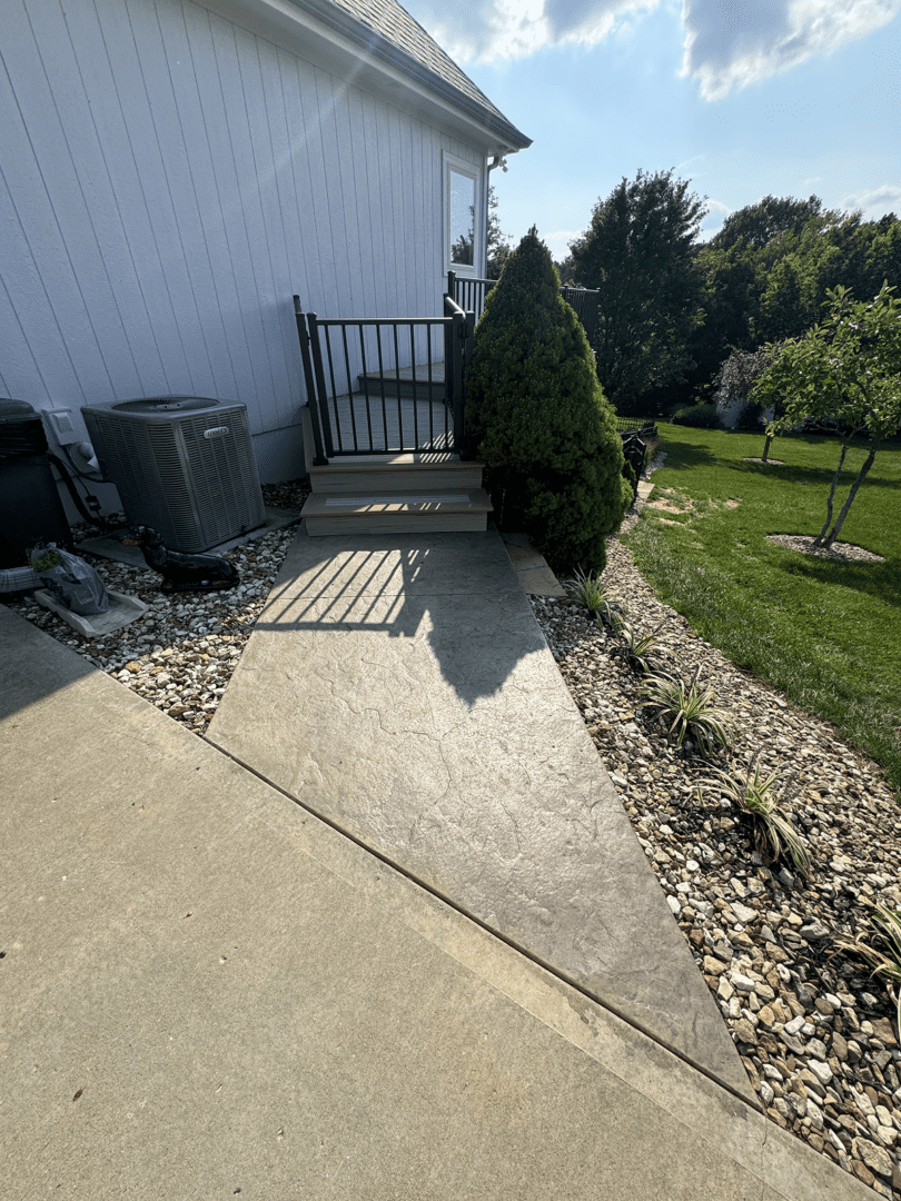 Concrete patio area with landscaping and garden view.
