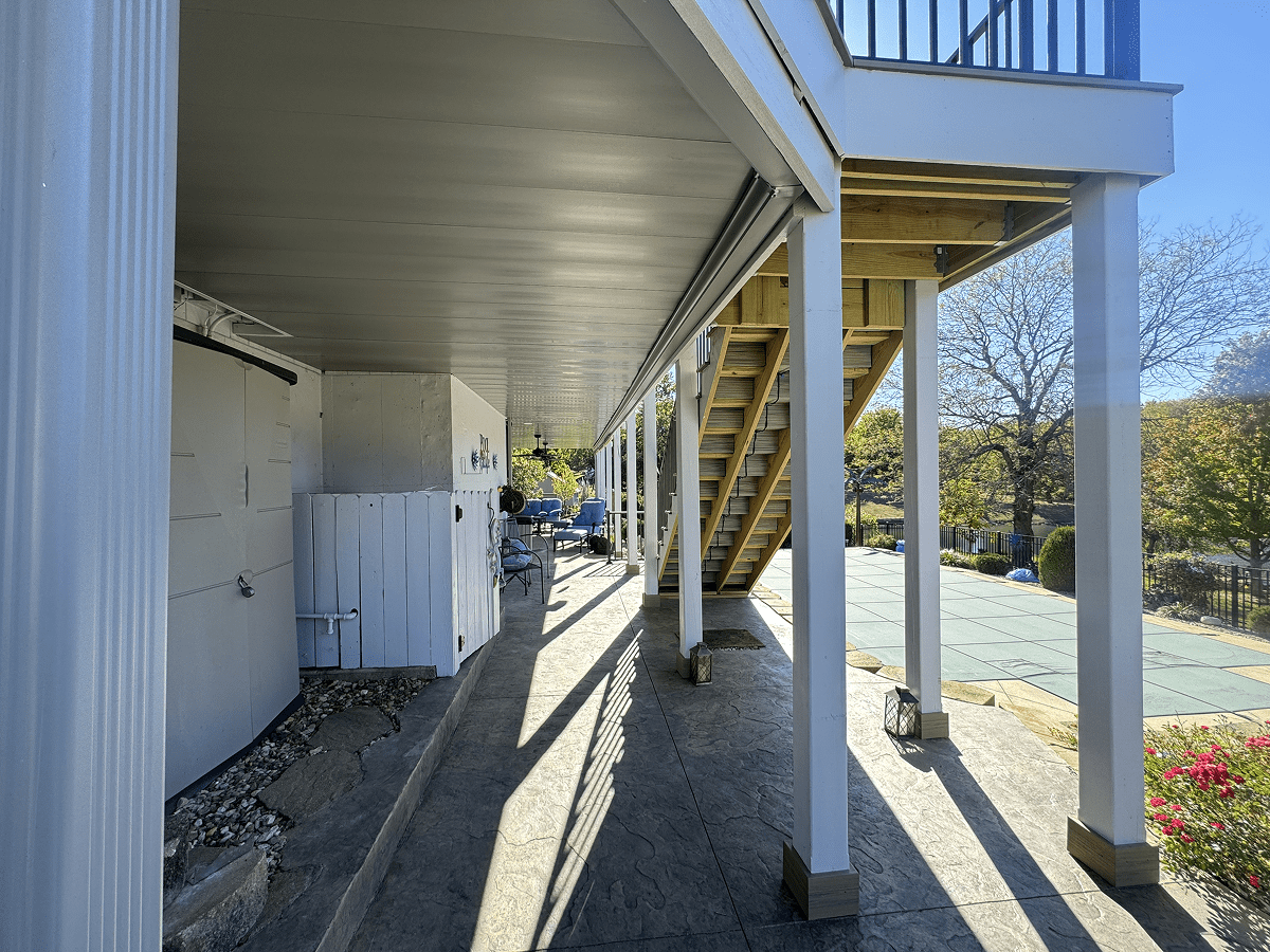 Outdoor staircase casting shadows on a sunny day by a building.