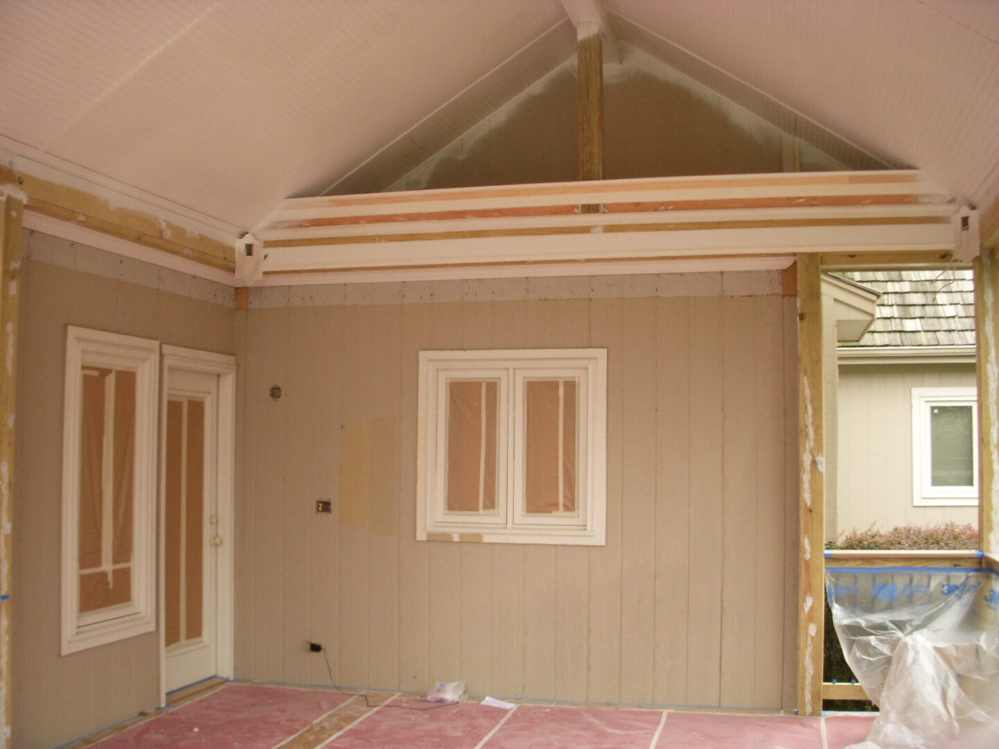 Interior wall under construction with exposed beams and insulation.