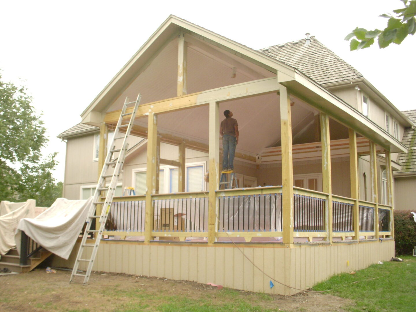 House under construction with workers on the porch.