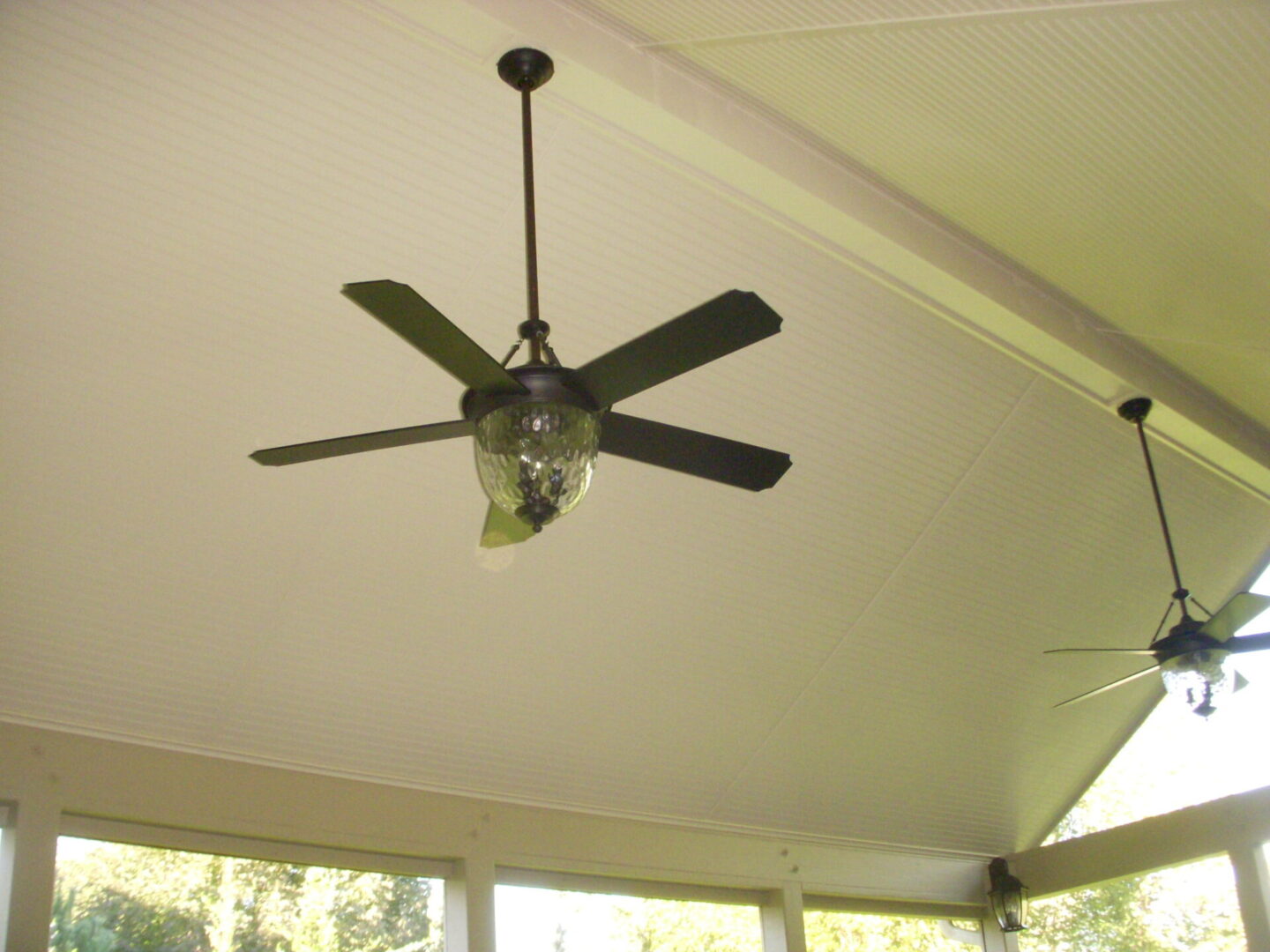 Ceiling fan with light fixture in a room with white ceiling.