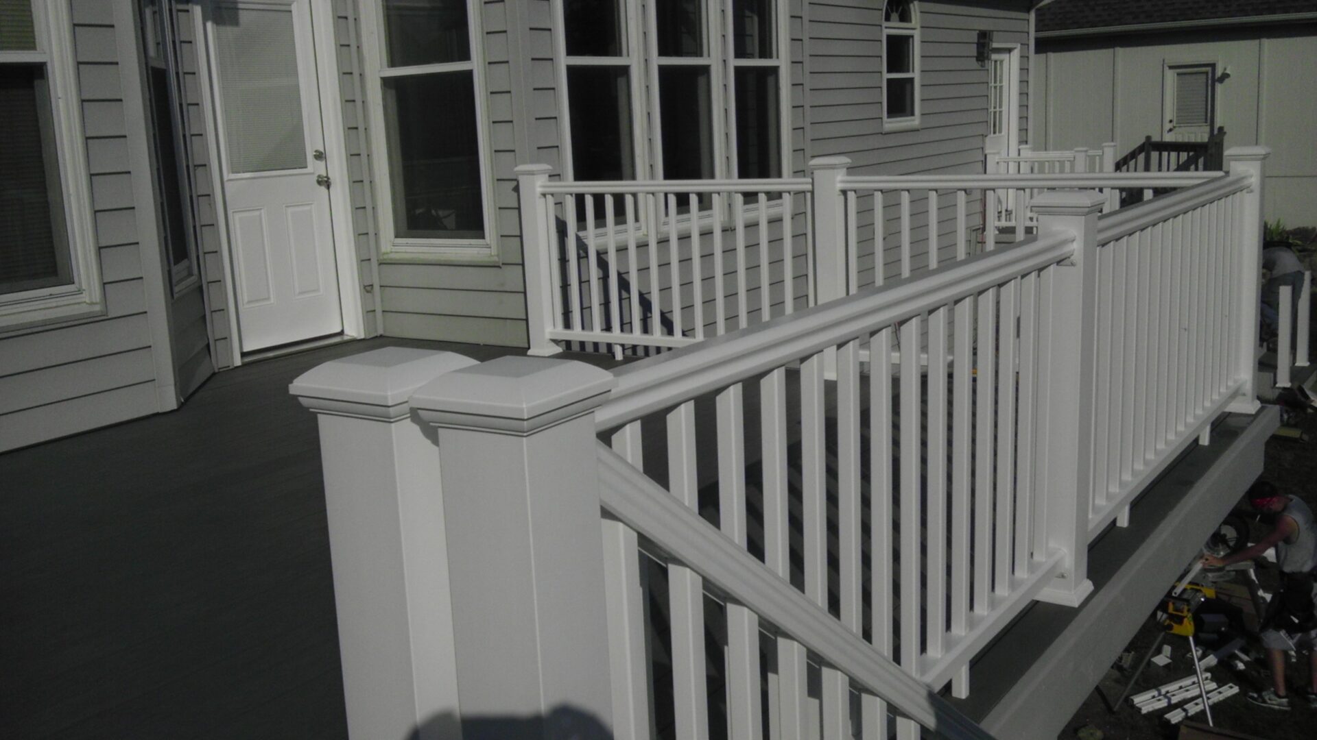 White wooden porch railing with square posts and balusters.