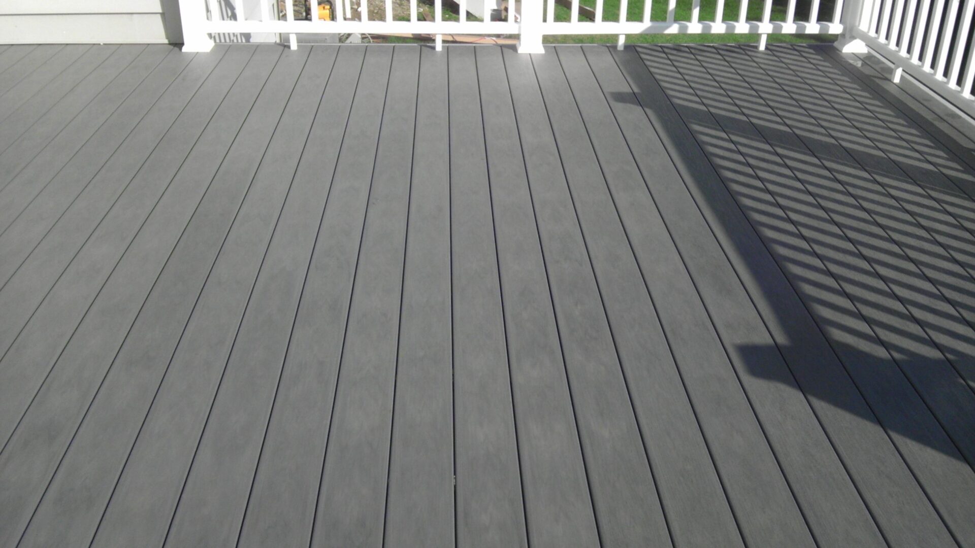 A gray composite deck with clean, straight lines and a white railing.