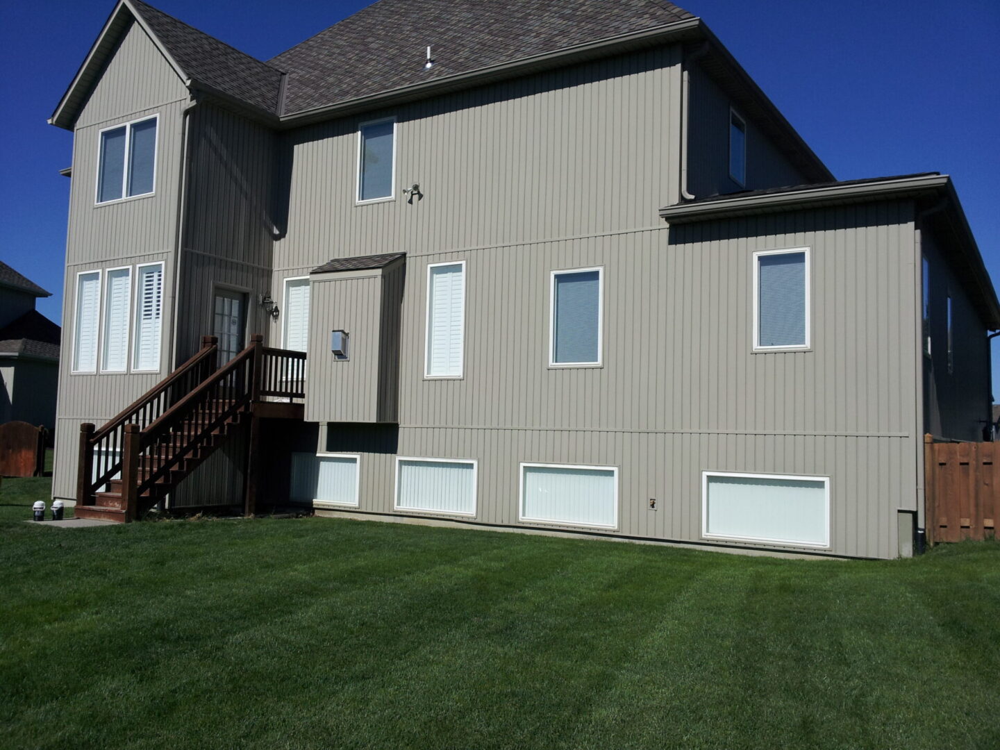 A house with a textured exterior and a green lawn.