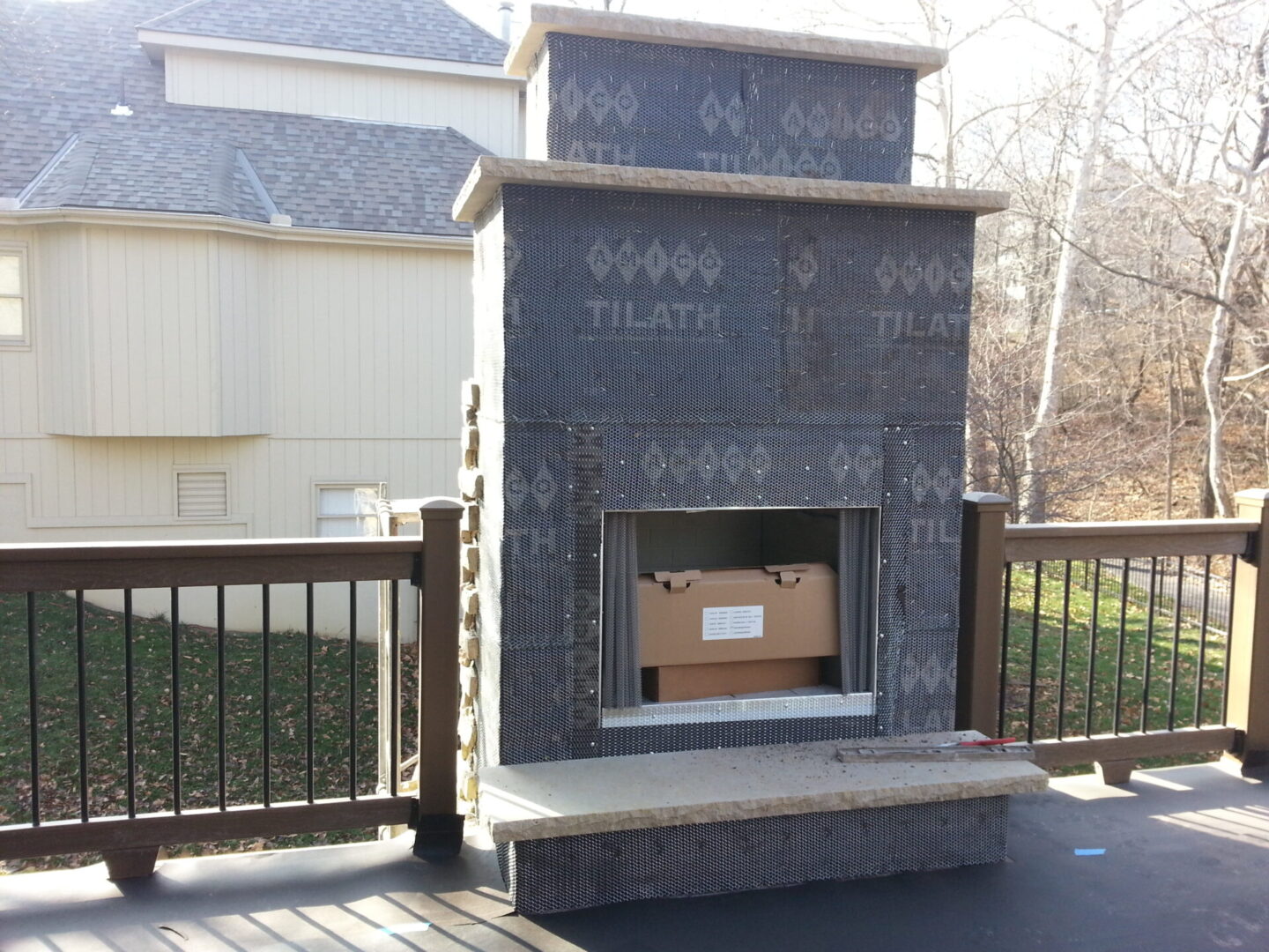 Outdoor stone fireplace with a cardboard box inside the firebox.